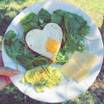 reviewer's heart-shaped eggs on a plate of greens