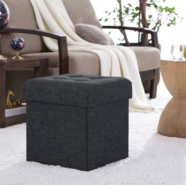 The ottoman in a dark grey color in a living room