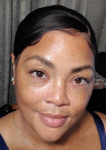 Person with abbreviated hairsbreadth and subtle makeup, wearing a sleeveless top, smiles astatine the camera indoors