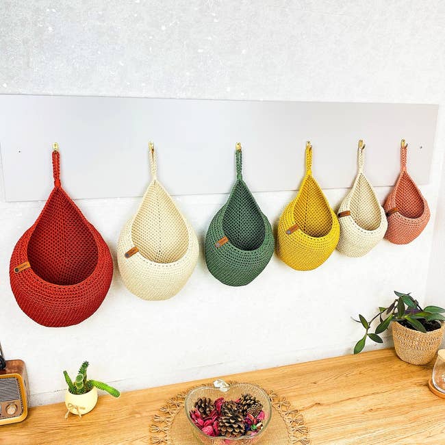 A enactment of woven hanging baskets successful assorted shapes and sizes connected a wall, perfect for location organization, with a woody support beneath displaying decor items
