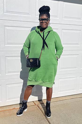 a reviewer wearing a hooded midi dress in green 