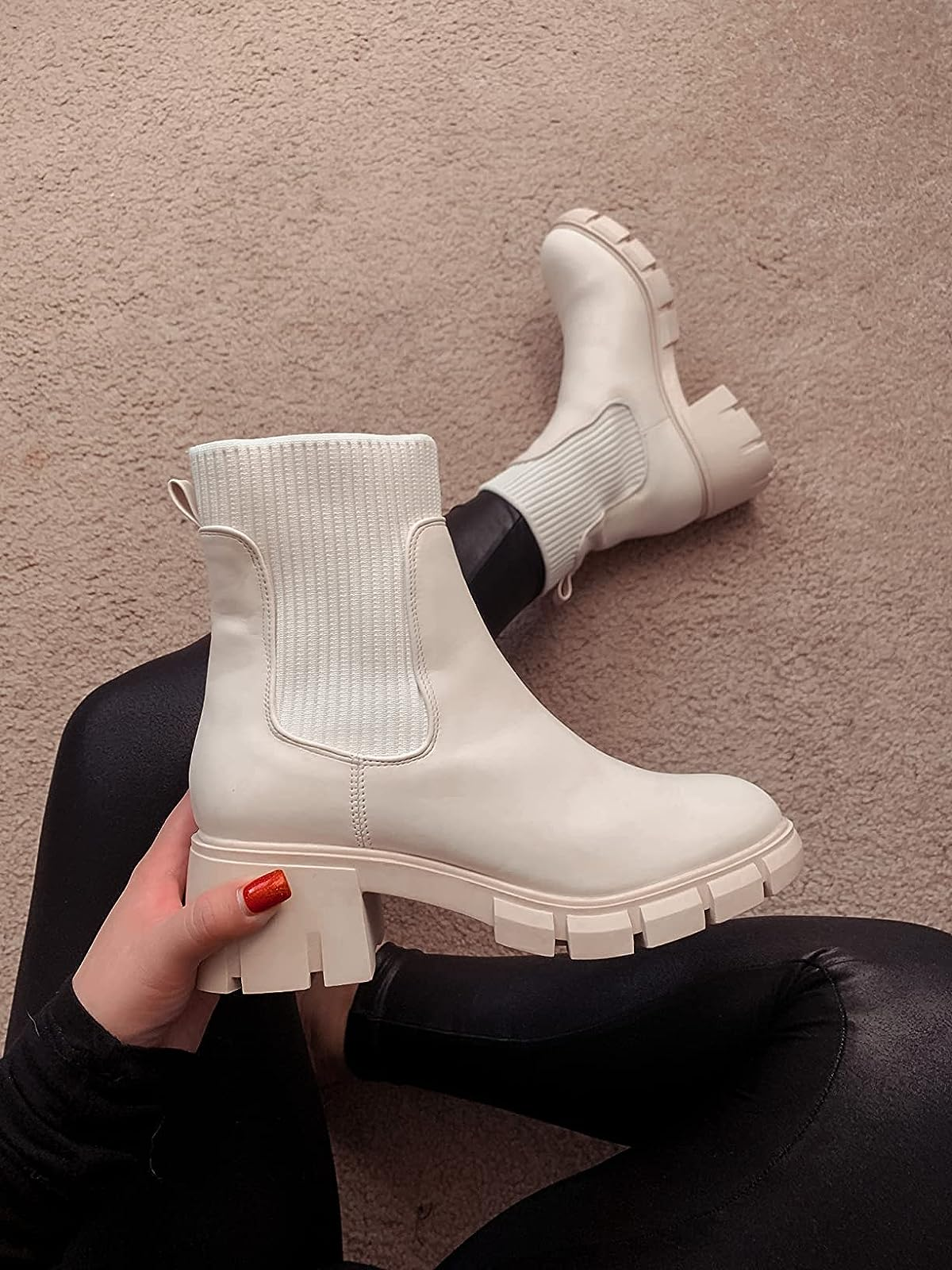 reviewer wearing and holding up   1  of the achromatic  boots