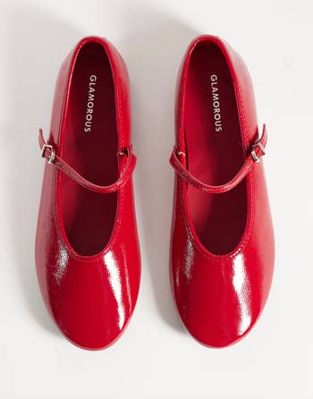 Glossy reddish Mary Jane shoes with a strap crossed the top, labeled