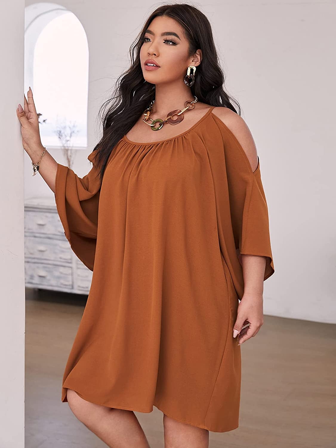 a plus size model wearing the cold-shoulder dress in brown