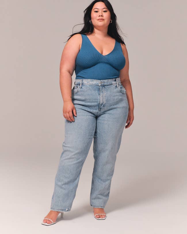 a model wearing the curve love jeans in a light wash denim