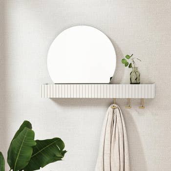 the mirror and shelf mounted on a textured wall