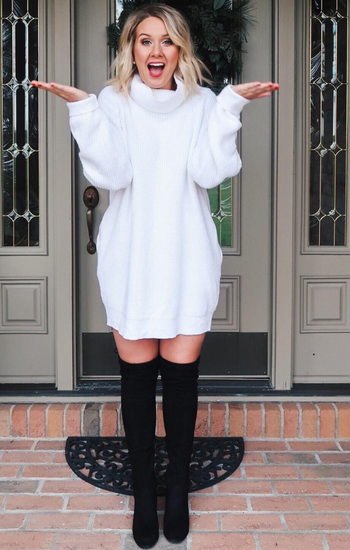 reviewer wearing the white dress with thigh-high boots