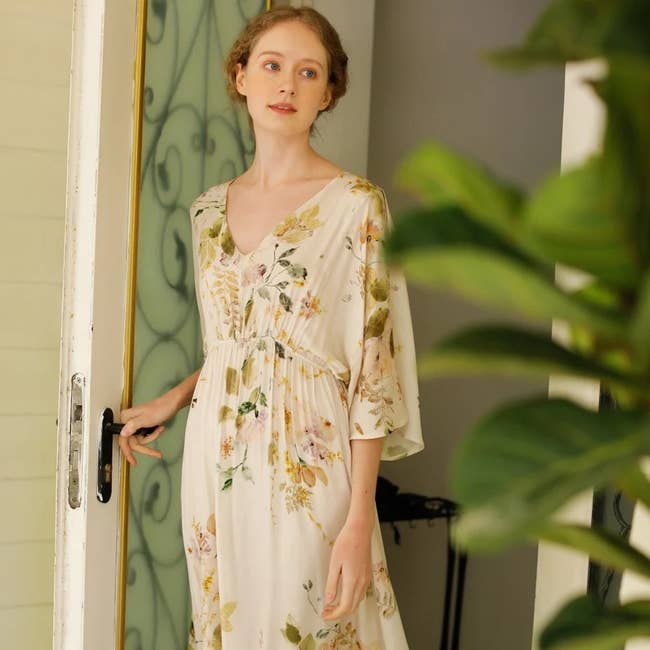 a model wearing an off-white maxi dress with a floral print 