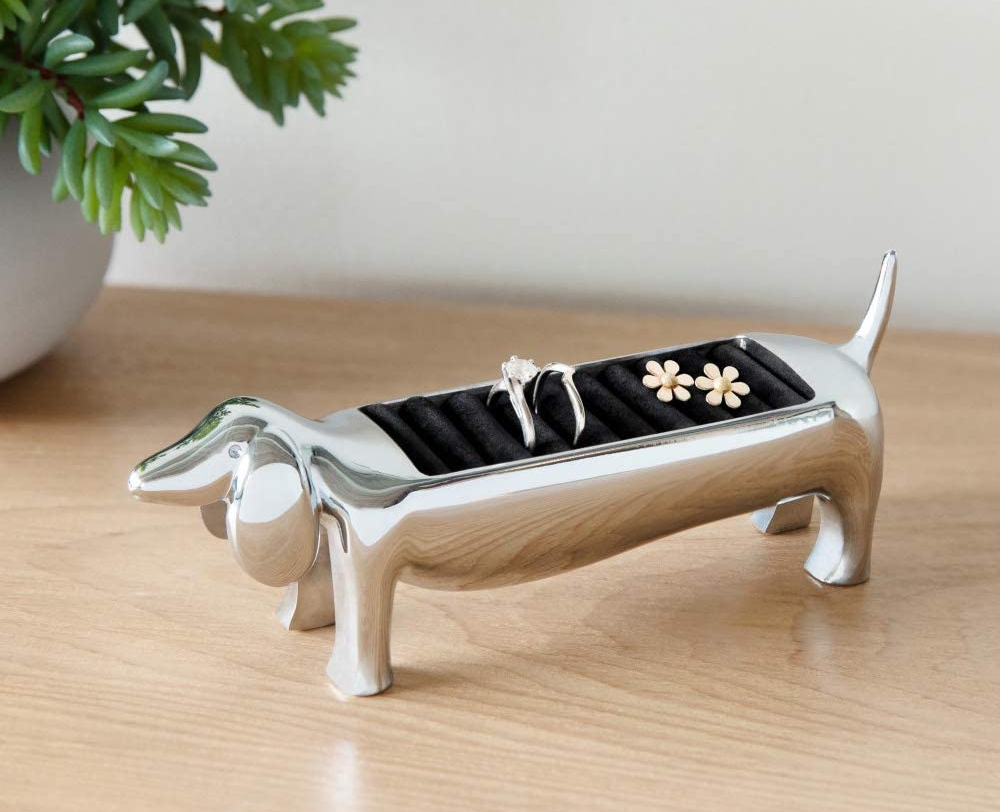 Silver dog-shaped ring holder with rings stored inside