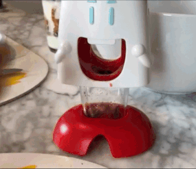 gif of a reviewer using the cherry pitter and showing how easy it is