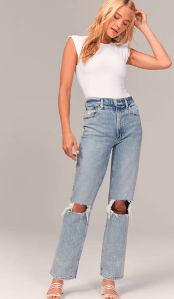 model wearing the straight leg jeans with holes in both knees