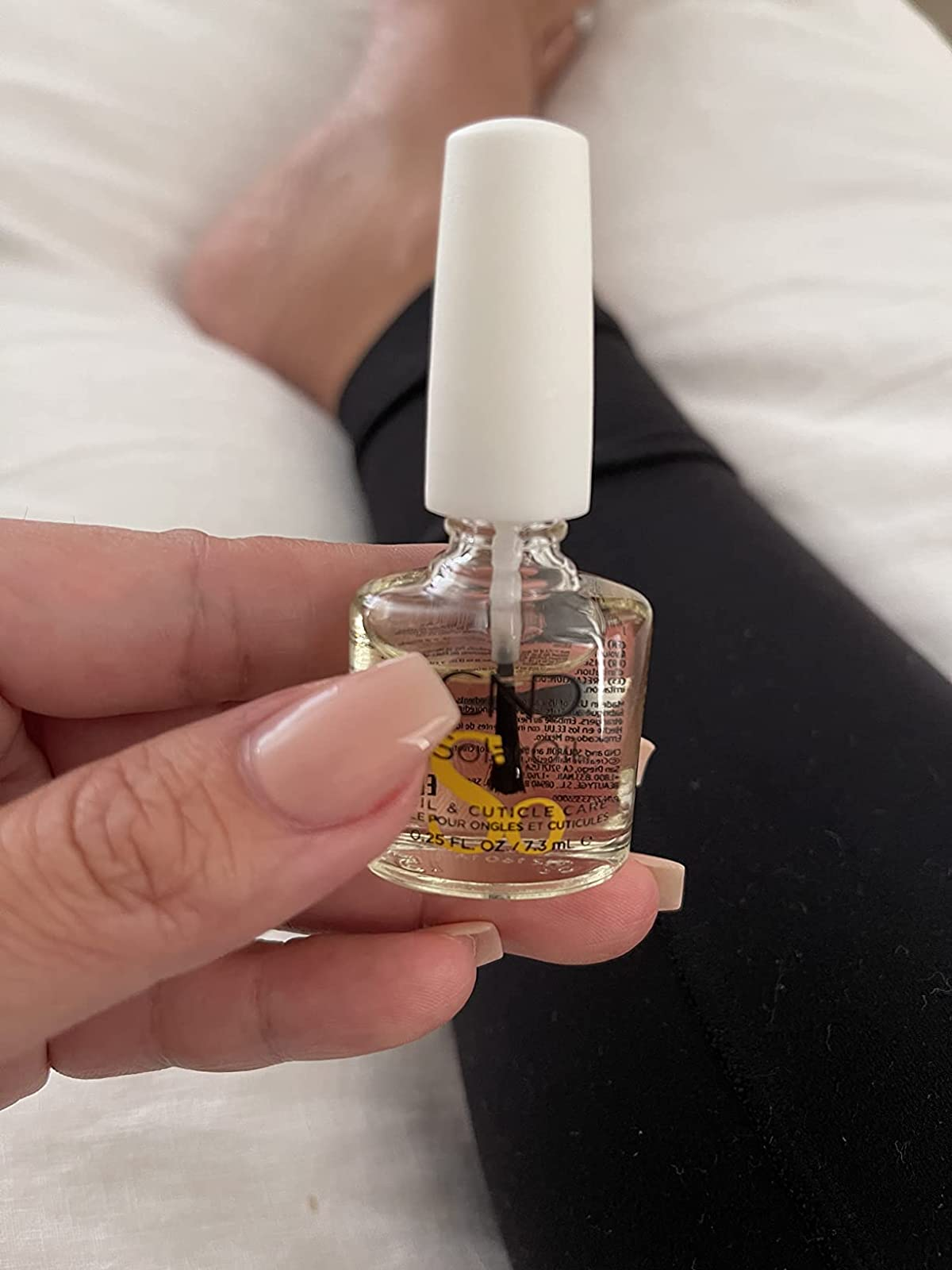 reviewer holding a bottle of the cuticle oil