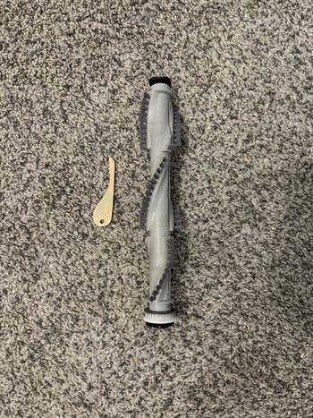 Vacuum brushwood  rotation  and cleaning instrumentality   connected  a carpeted floor, showcasing replacement parts for location  cleaning equipment