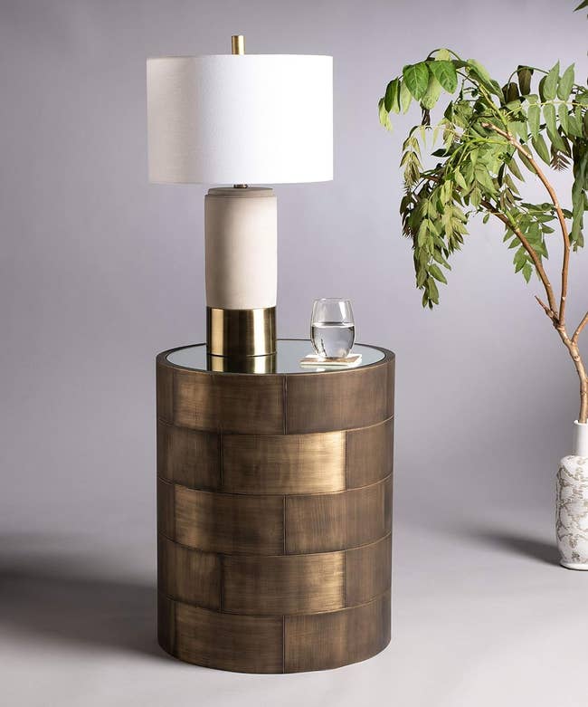 a table lamp atop the brass side table