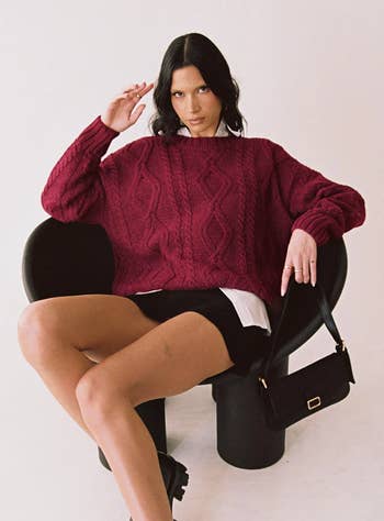 model wearing the burgundy sweater with a white collared shirt and a black skirt