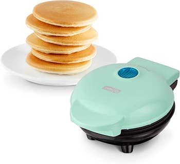 The mini pancake griddle in aqua with a stack of pancakes