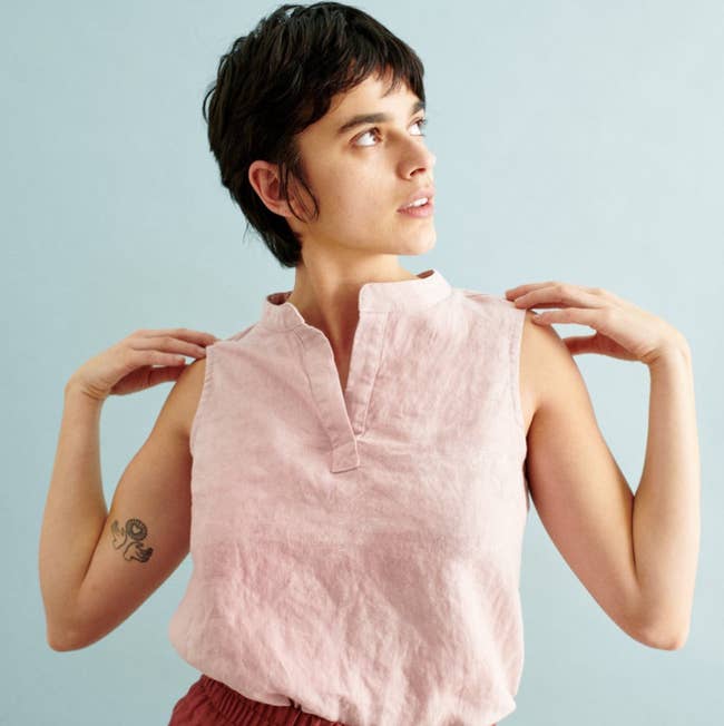 a model wearing the linen tank top in a light pink color