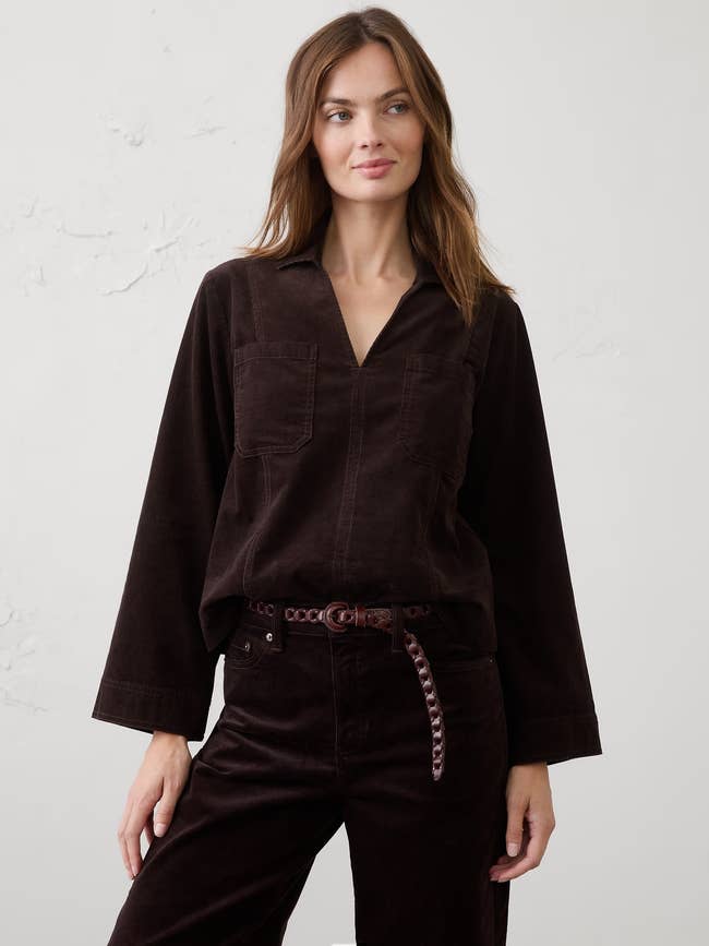Model wearing a corduroy apical with agelong sleeves and matching pants, accessorized with a stylish belt