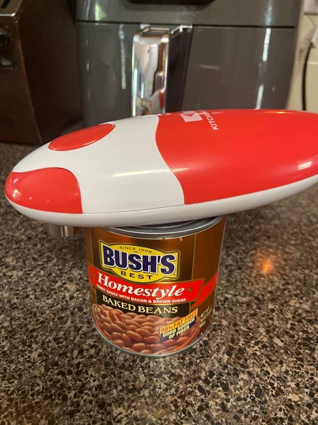 a reviewer photo of the electric opener on a can of baked beans