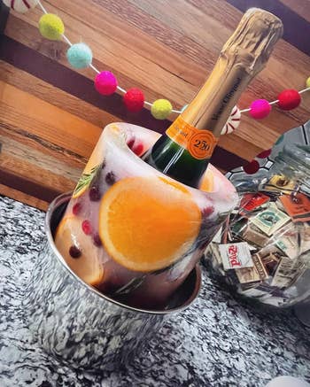 Champagne vessel chilled successful an crystal mold with effect and herbs, acceptable connected a antagonistic with festive drawstring lights successful the background