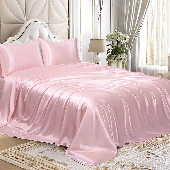 the pink satin sheet set on a bed