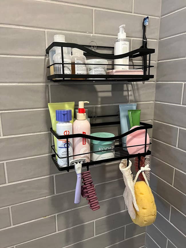 reviewers two shelves with bottles of shampoo and shower essentials on it in a shower 
