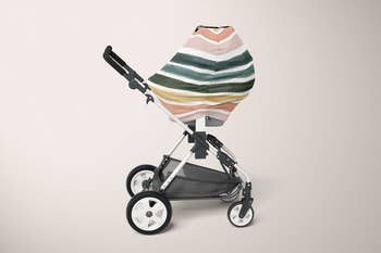 The rainbow pastel striped cover over a stroller 