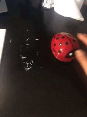 gif of a reviewer using the vacuum to clean up crumbs on a desk