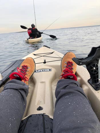 reviewer POV photo wearing the hiking boots on a kayak