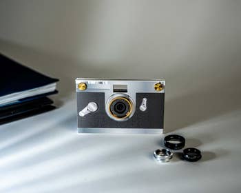 paper shoot camera next to three lenses
