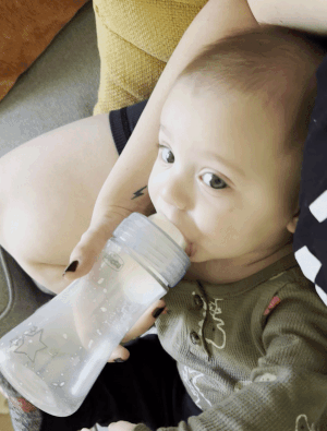 a gif of editor's baby drinking out of a chicco duo bottle