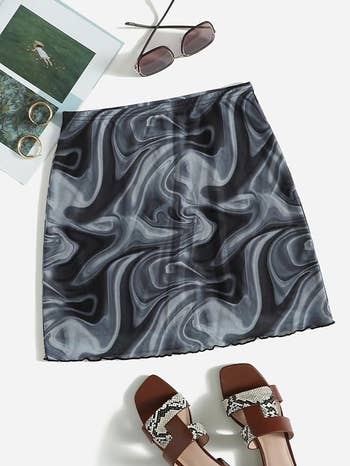 Marble pattern skirt with coordinating accessories laid out flat for a fashion article