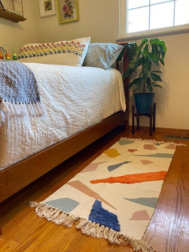 reviewer image of the long tassel rug with different colored shapes and colors