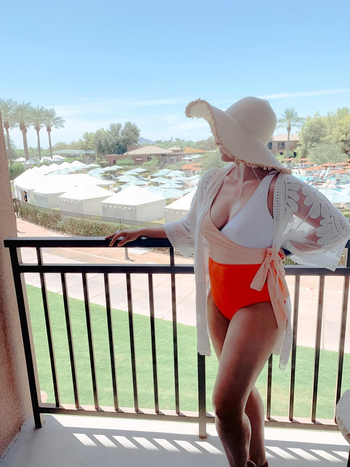 reviewer wearing the suit in white and orange