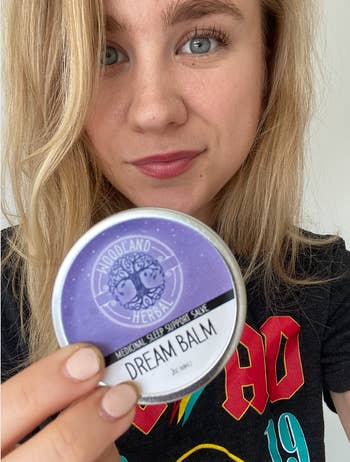 BuzzFeed editor holding purple canister of dream balm 