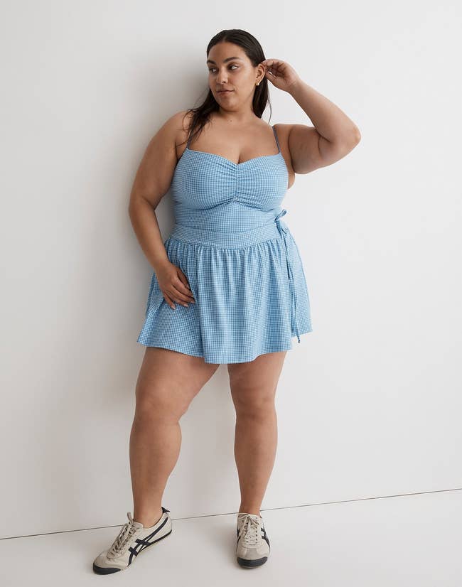 a model in a blue gingham tank and skirt