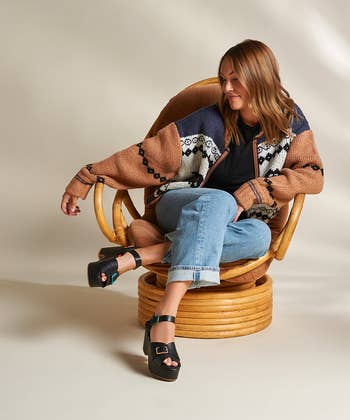 model wearing the black sandals with multicolored buckles