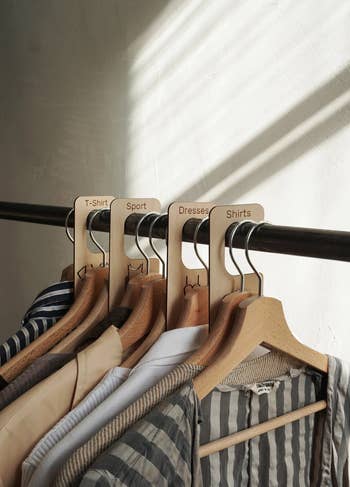 the wooden dividers organizing clothes on a rack