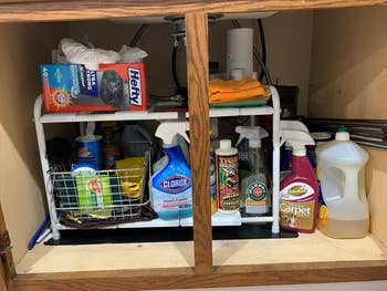 reviewer showing the cabinet after adding the shelf and how organized it is