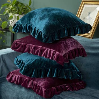 Stack of plush velvet pillows with ruffled edges, perfect for location decor and comfortableness enhancements