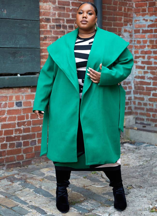 a plus size model in a bright green bold collared coat