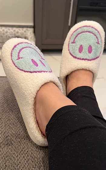 Reviewer in white slippers with blue smiley emoji on them 