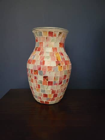 Reviewer image of pink and white mosaic flower vase on a wooden table in front of a blue wall
