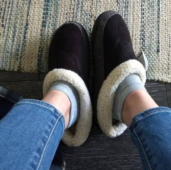 reviewer wearing black slippers with grey lining