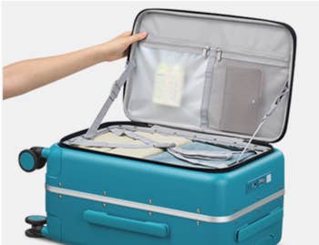 Person opening a suitcase with organized compartments containing assorted question essentials, showing businesslike packing options