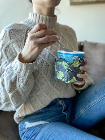 Model holding a plant-patterned cozy
