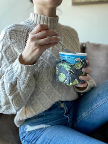 Model holding a plant-patterned cozy 