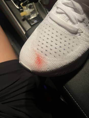 Reviewer's white shoe with a red stain on the top of the toe area