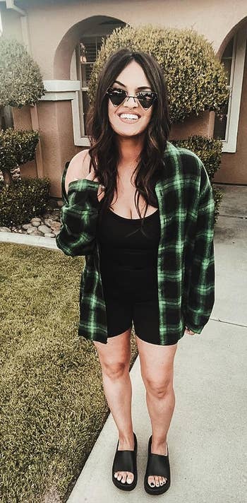 reviewer posing, smiling, wearing green plaid flannel top