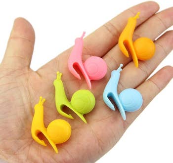 hand holding the snails in assorted colors